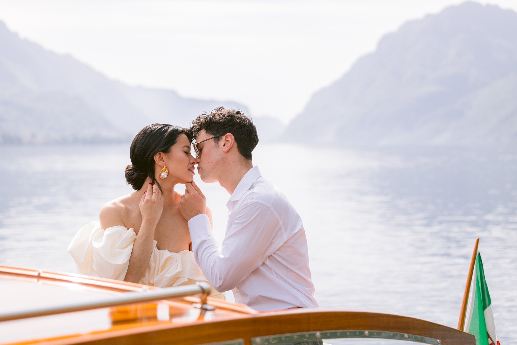 how-to-elope-in-italy-lake-como-couple-kissing-wooden-boat-moon-rising-photography-lake-como-elopement-italy-italian-elopement-photographer-8026.jpeg